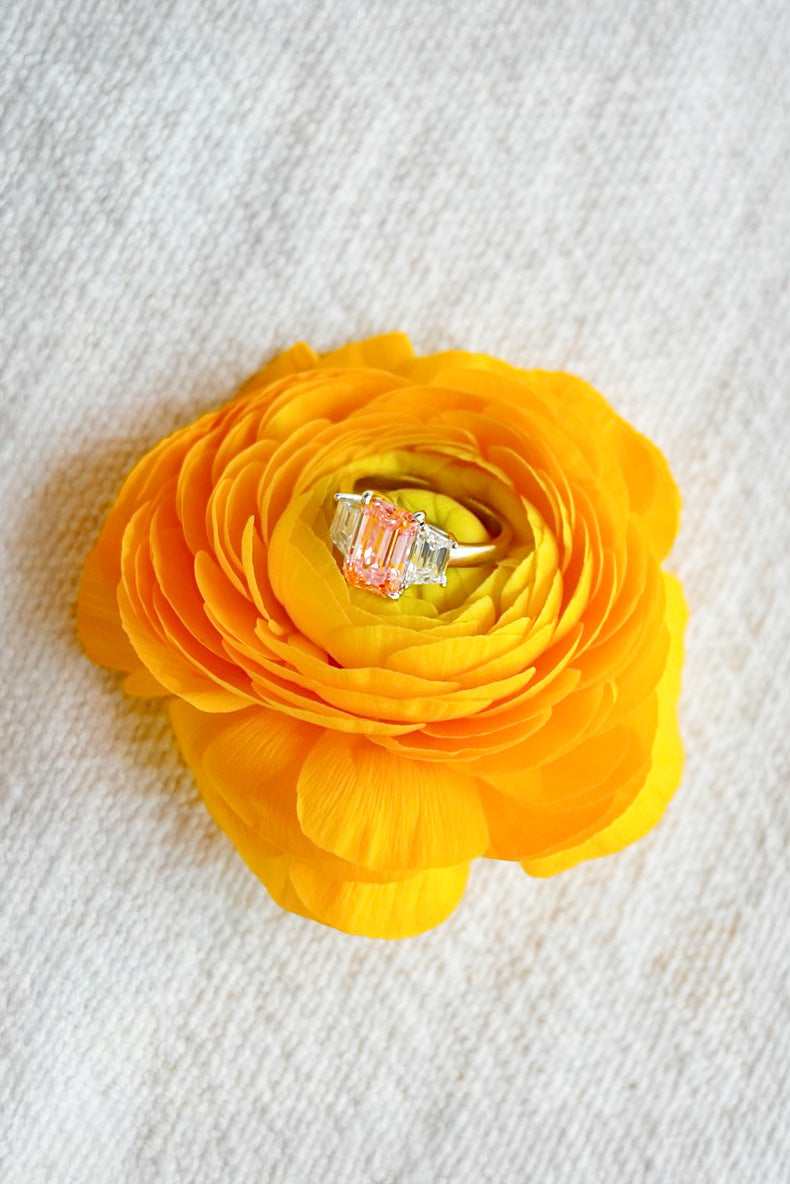 Pink tourmaline ring inside a yellow flower on a textured white background