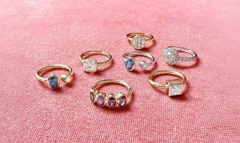 Set of rings with gemstones on a pink fabric background