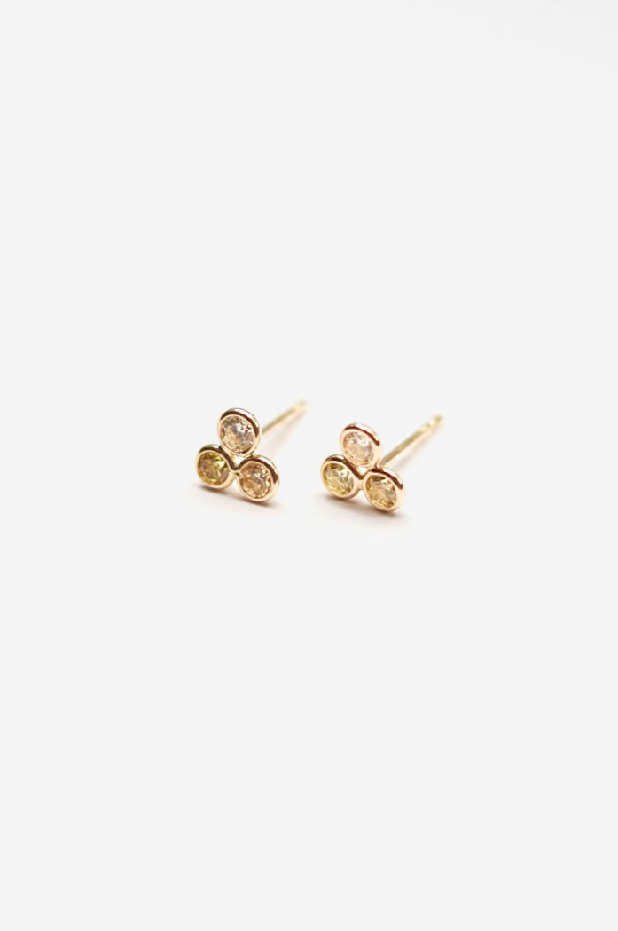 Gold citrine and diamond stud earrings on a white background
