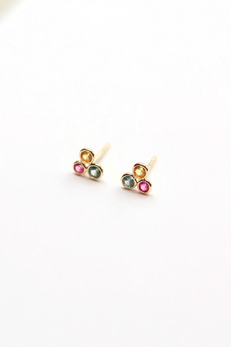 Pair of earrings with multicolored gemstones on a white background