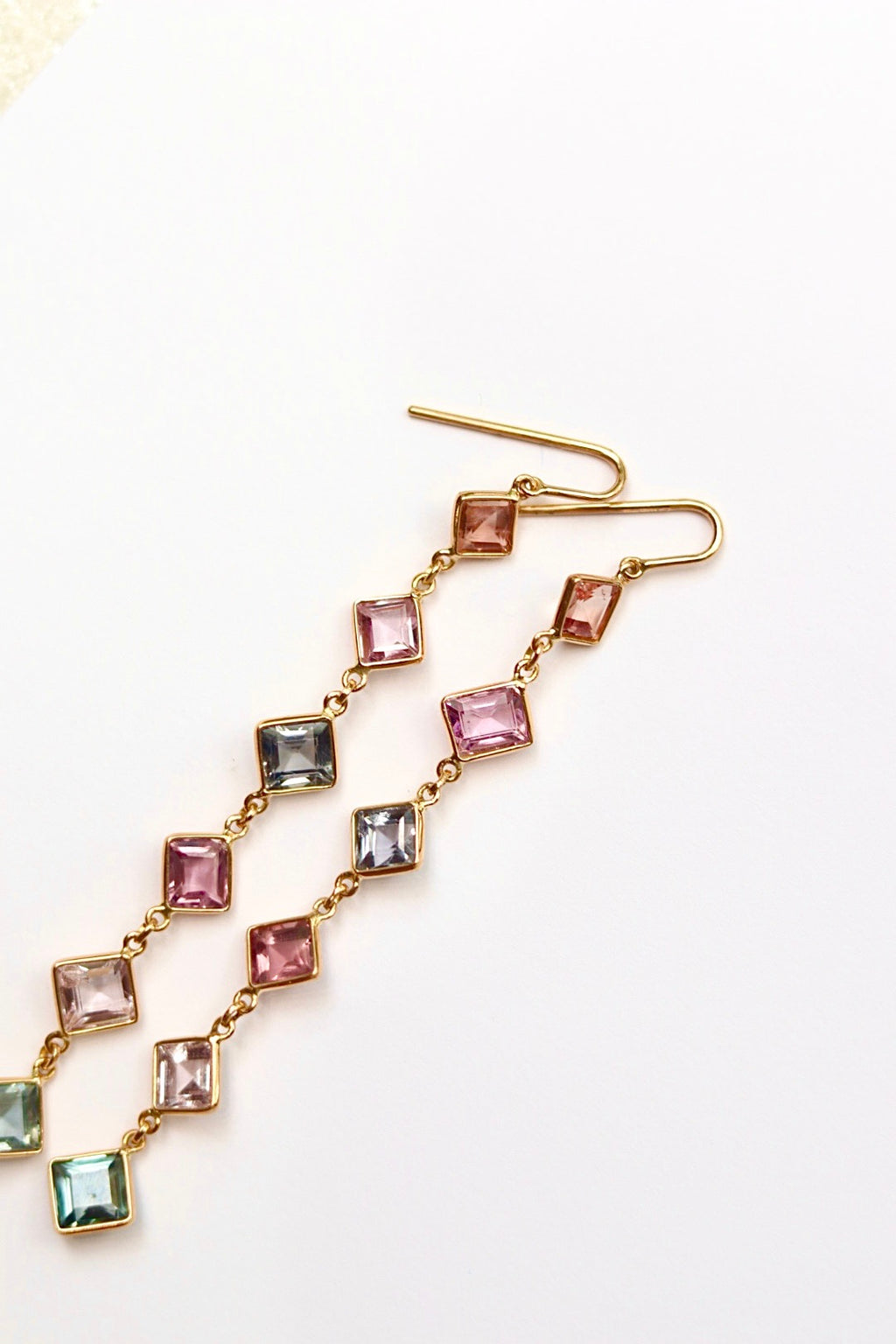 Multicolored gemstone earrings on a white background