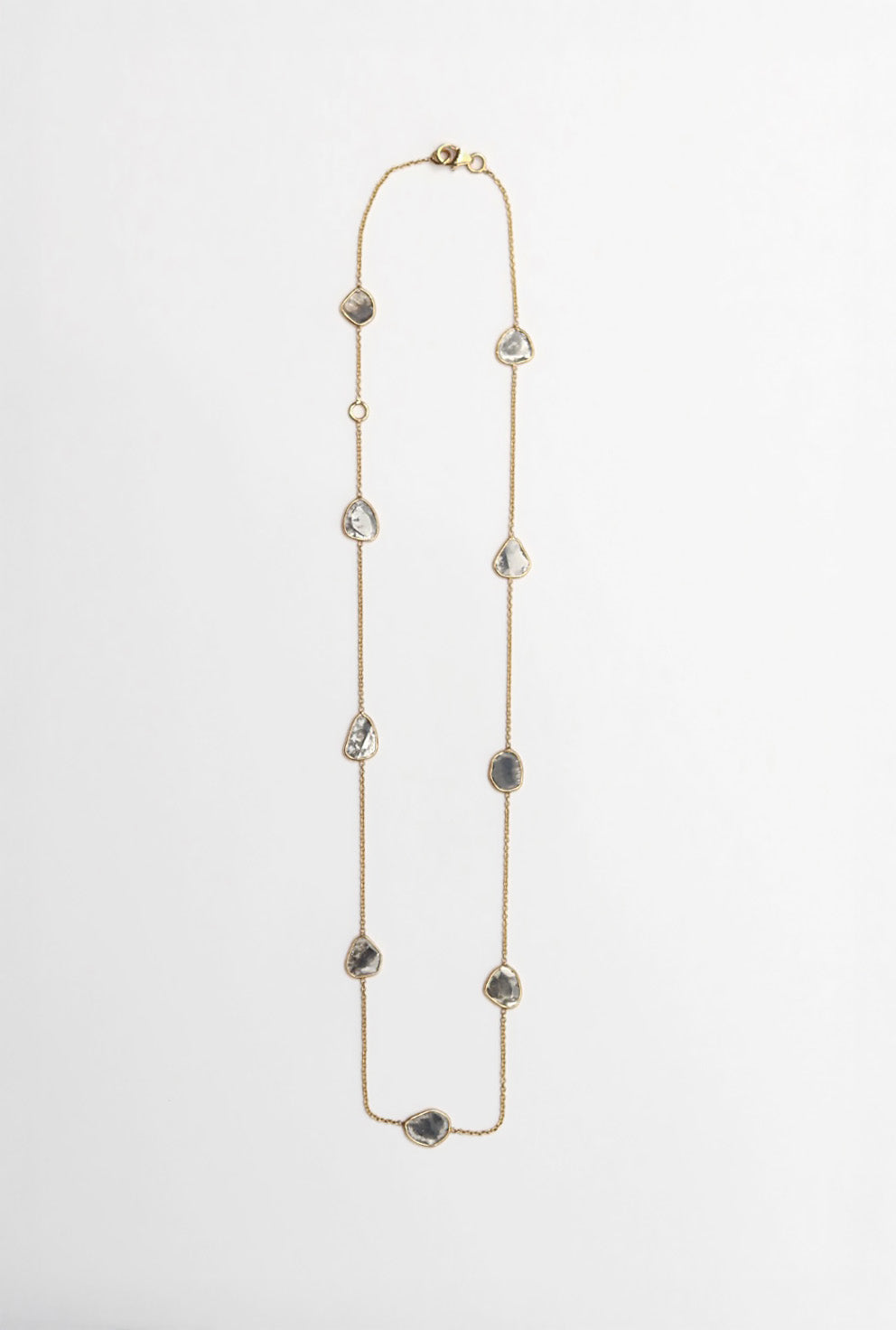 Long necklace with variously shaped diamond slice beads on a light gray background