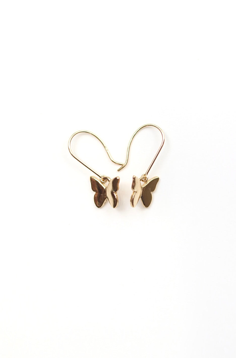 Gold butterfly earrings on a white background