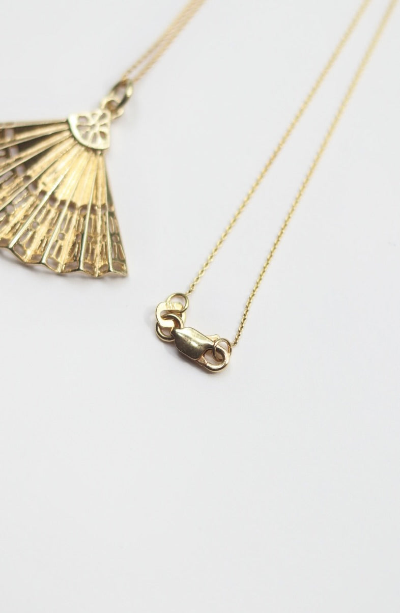 Gold necklace with a unique clasp on a white background