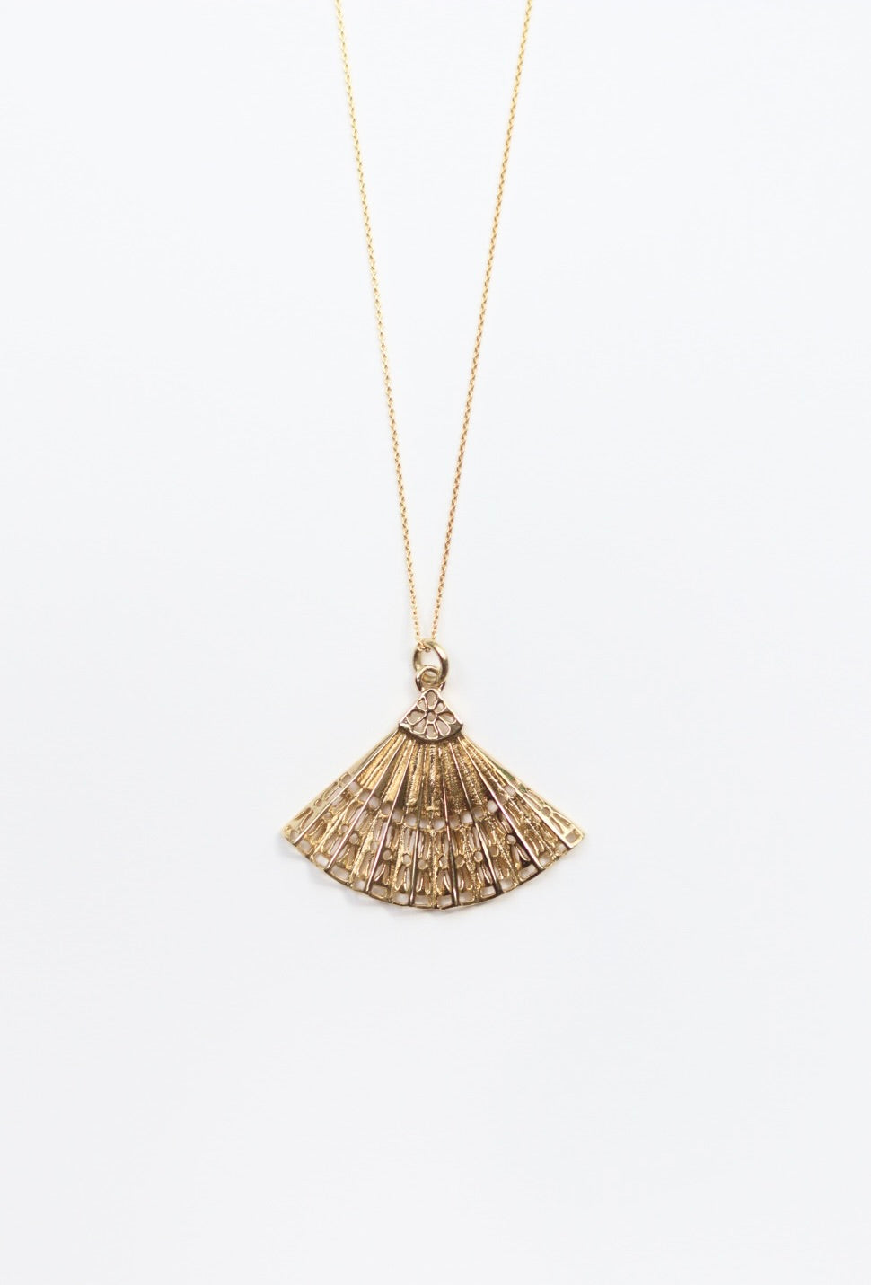 Gold necklace with a fan-shaped pendant on a white background