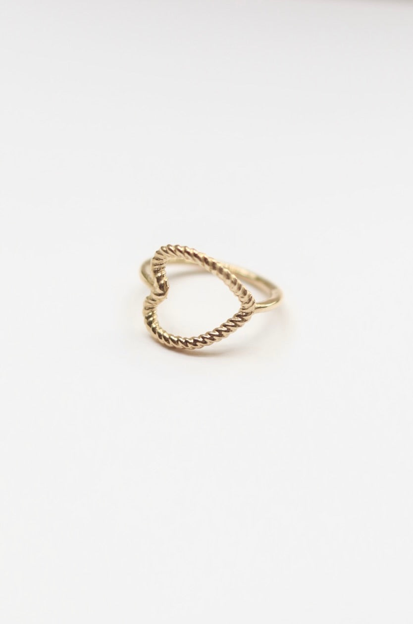 Gold ring with a twisted design on a white background