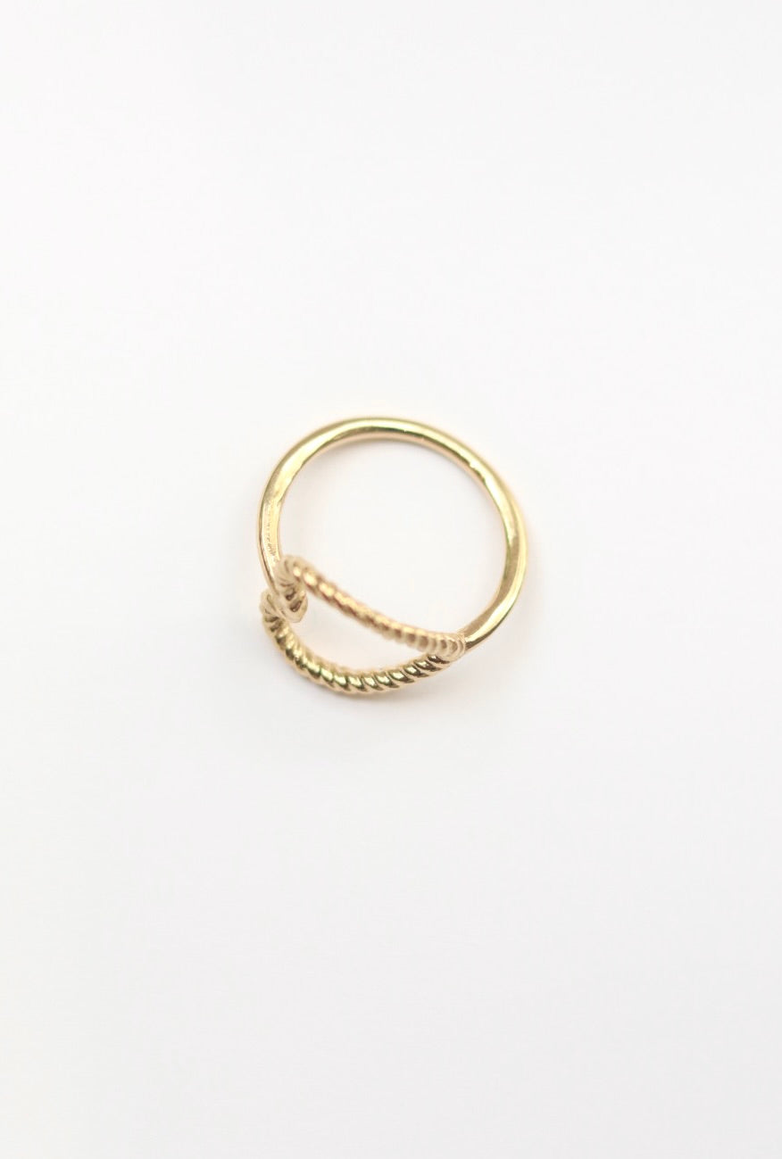 Gold ring with a textured band on a white background