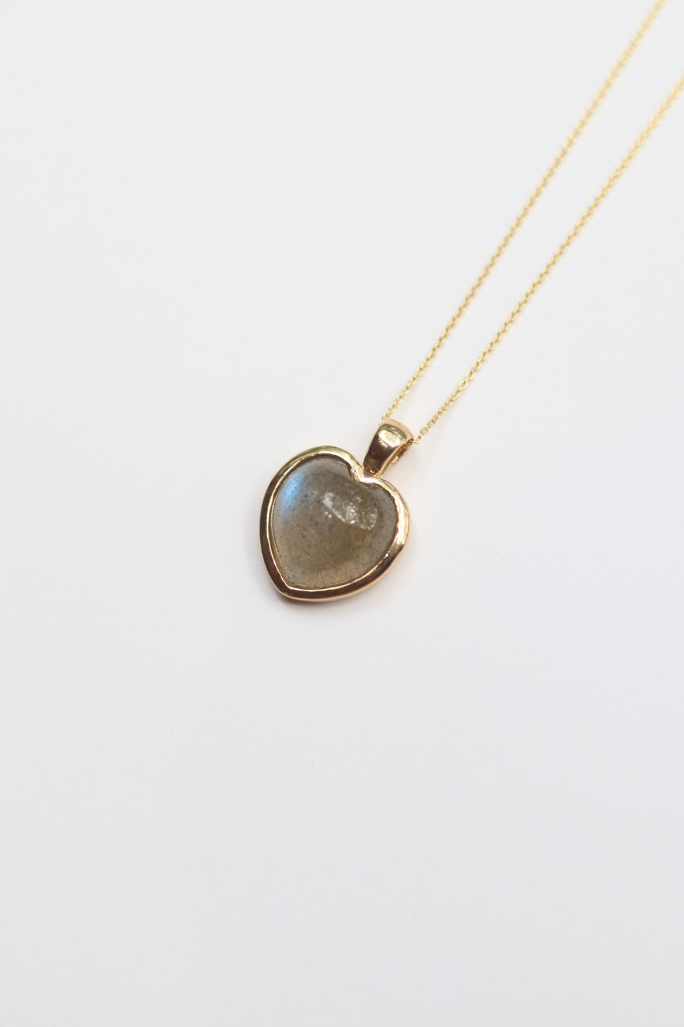 Heart-shaped labradorite pendant necklace on a white background
