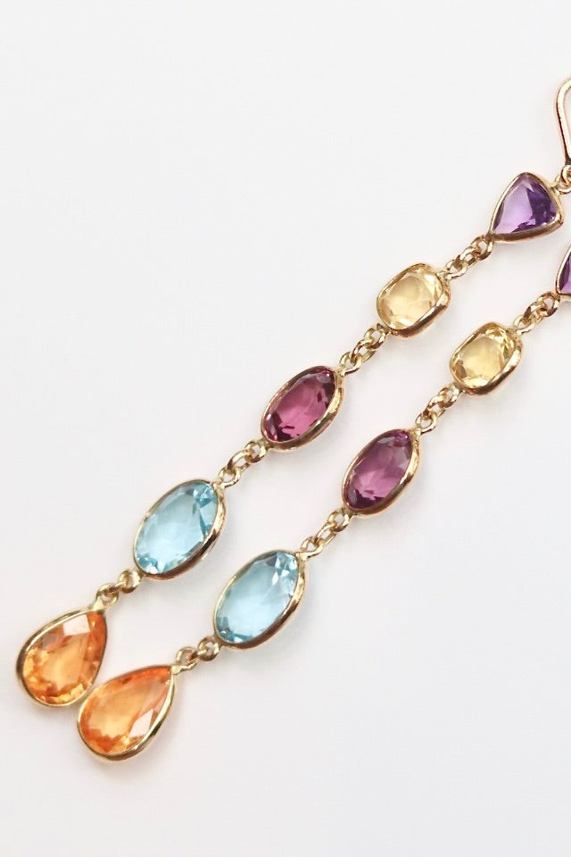 Multicolored gemstone earrings on a white background