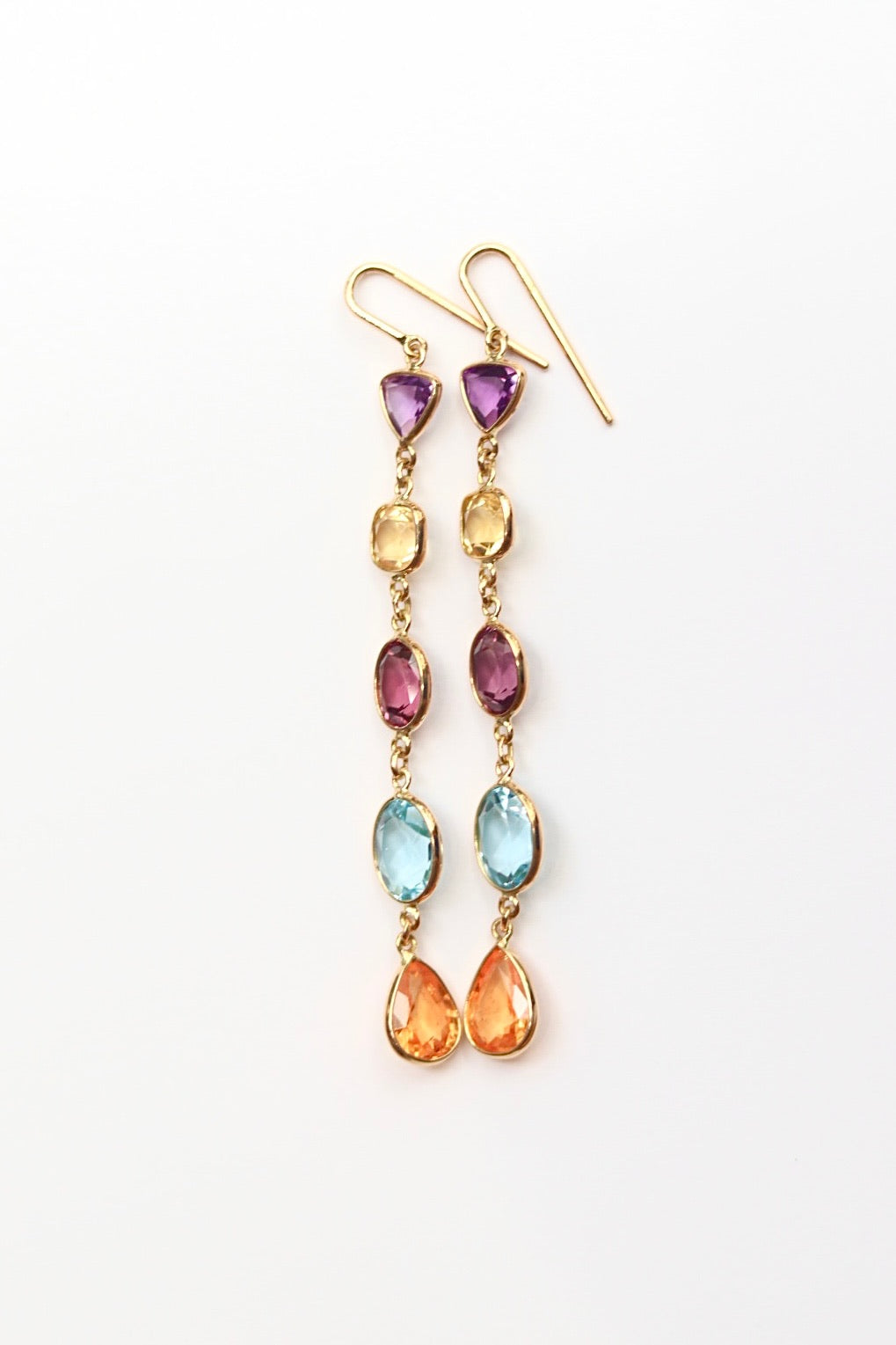 Multicolored gemstone earrings on a white background