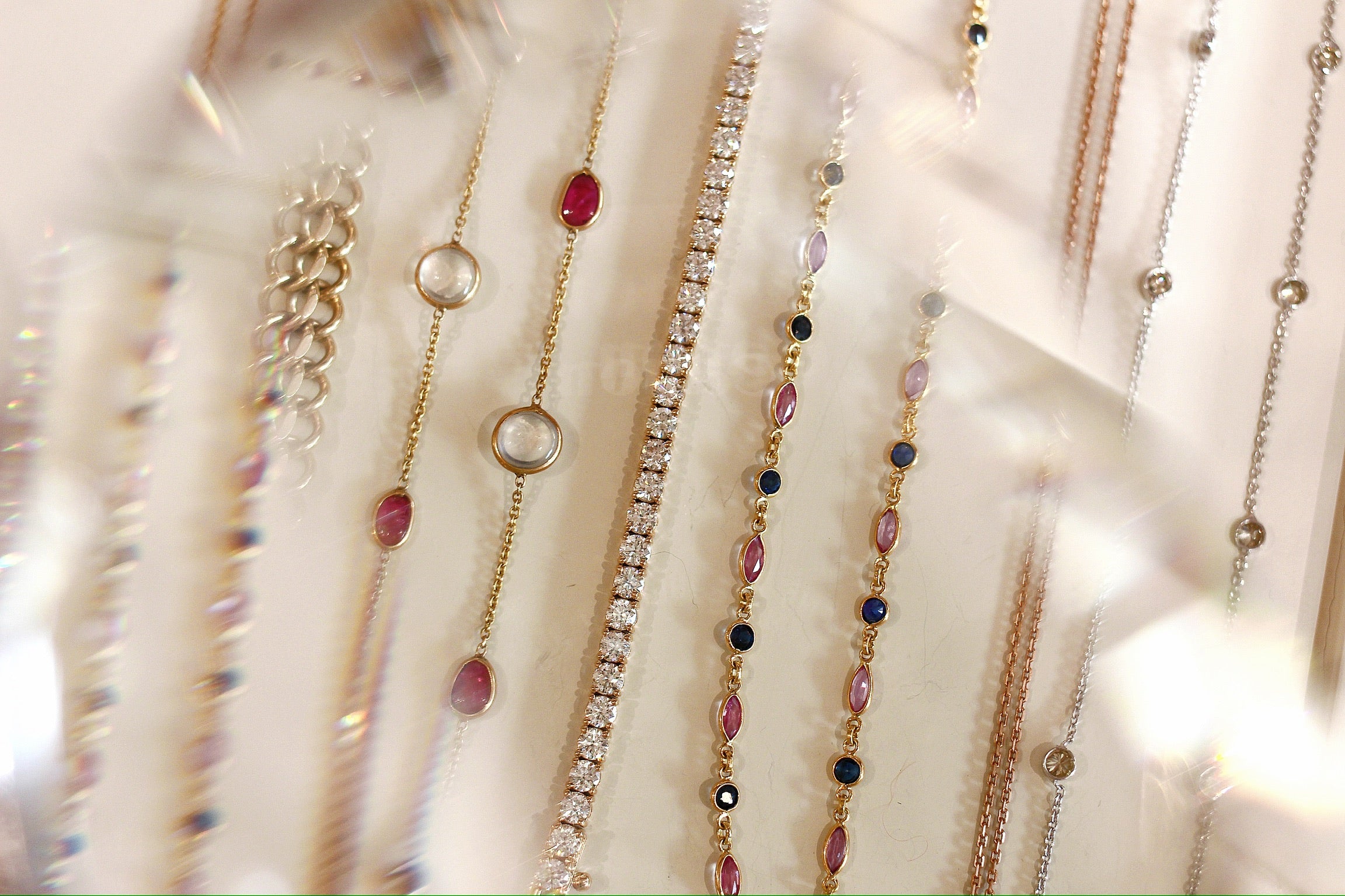 Necklaces and bracelets on a shadowy white surface