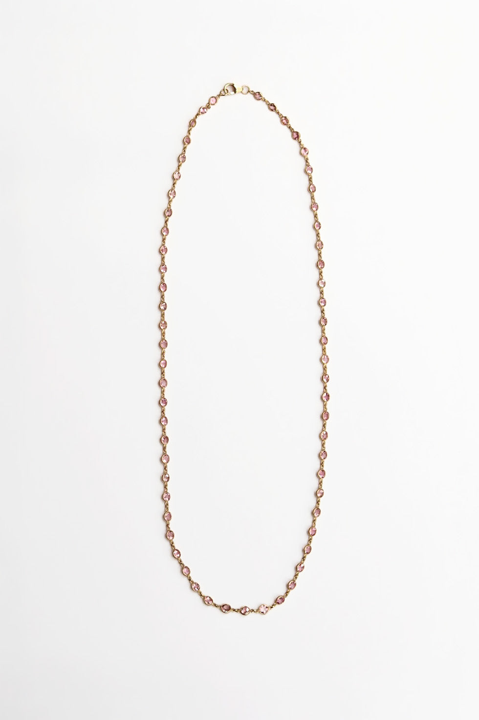 Gold chain necklace with pink oval gemstones on a white background