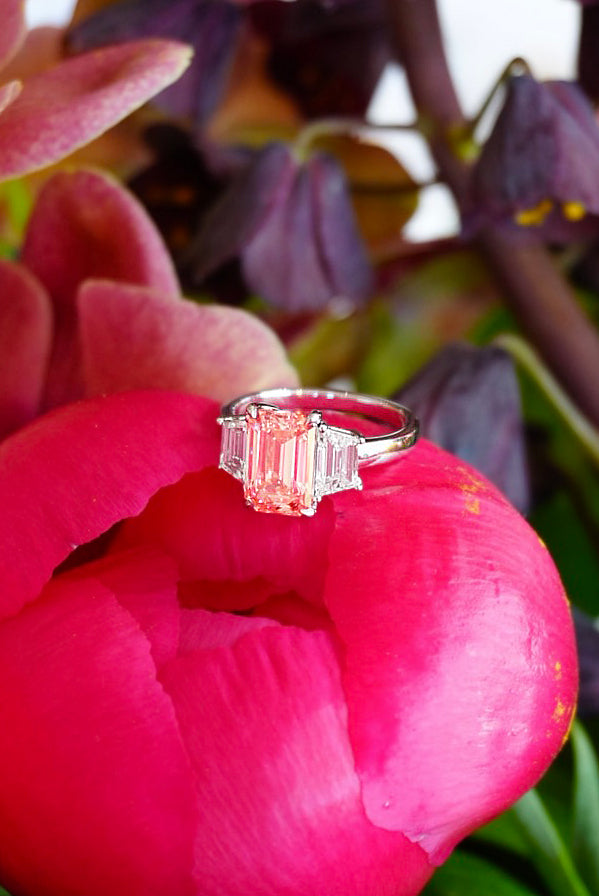 Diamond ring on a pink flower with blurred flowers in the background