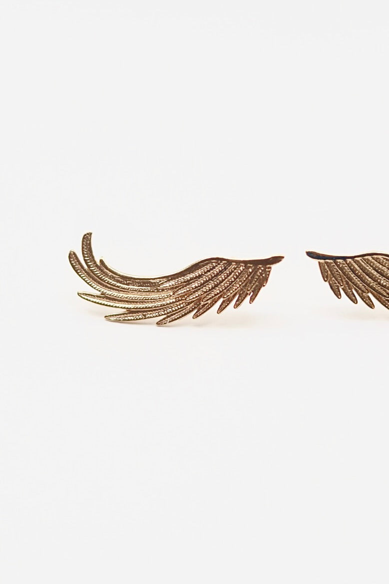 Marissa Alperin gold wing-shaped earrings on a white background