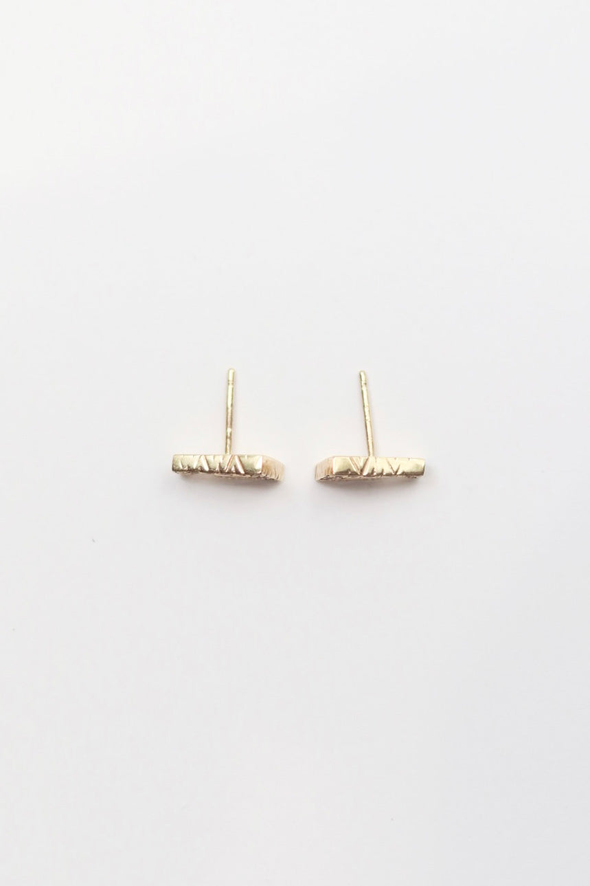 Gold bar earrings on a white background