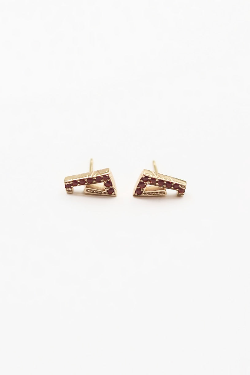 Pair of gold earrings with red gemstones on a white background