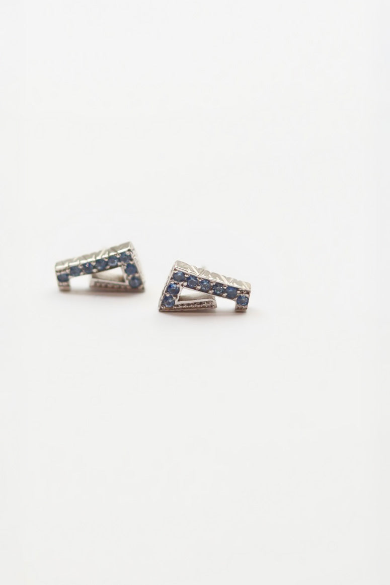 Pair of silver earrings with blue stones on a white background