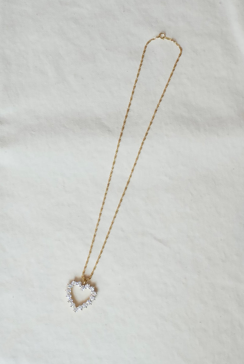 Necklace with a heart-shaped diamond pendant on a light background
