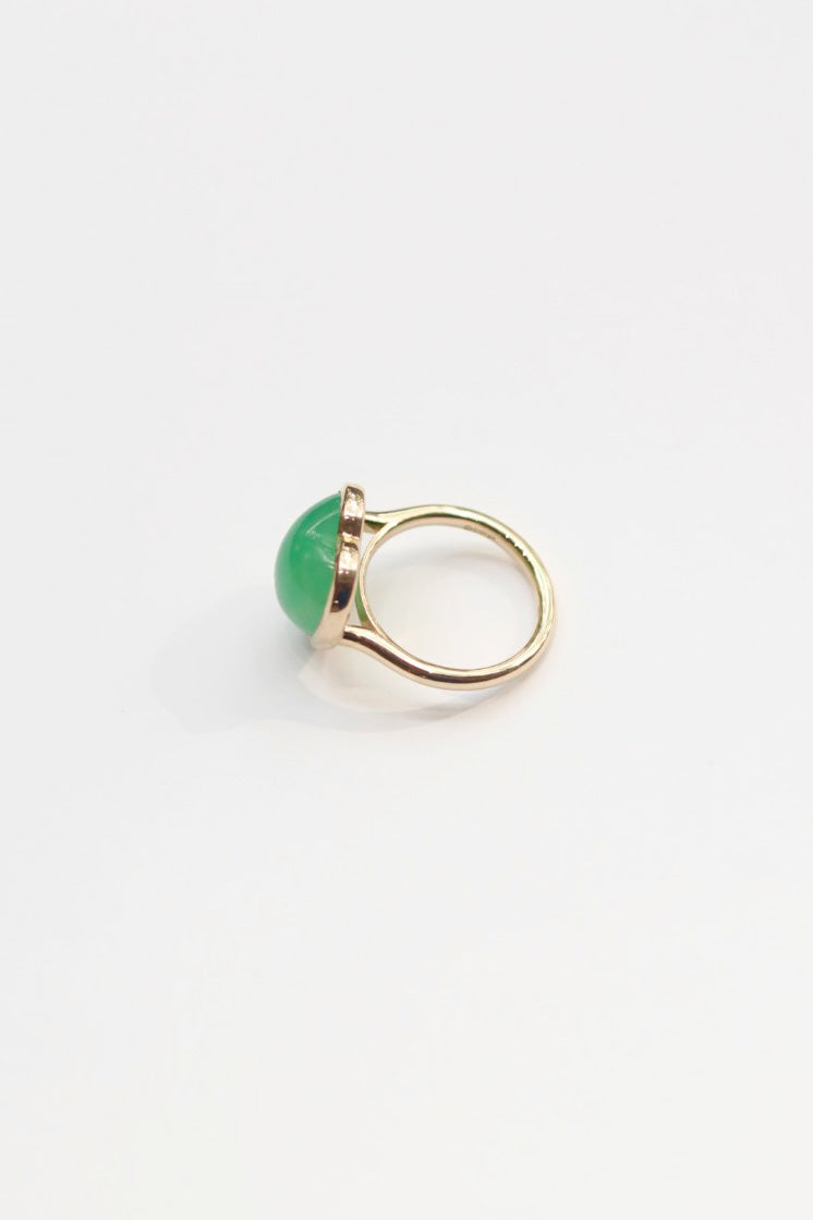 Gold ring with a green gemstone on a white background