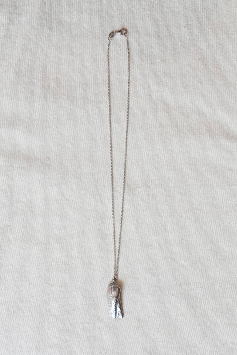Silver shell necklace on a light gray background