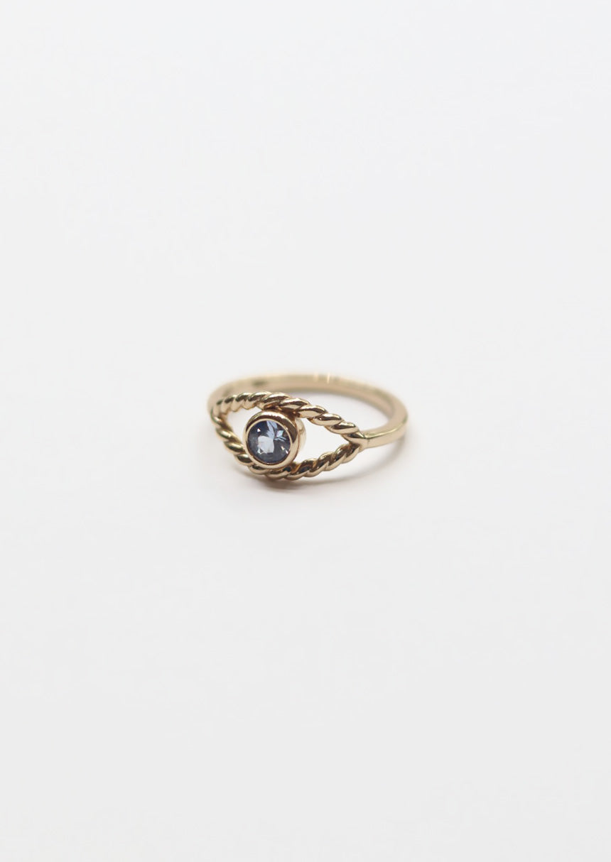 Gold ring with a purple gemstone on a white background