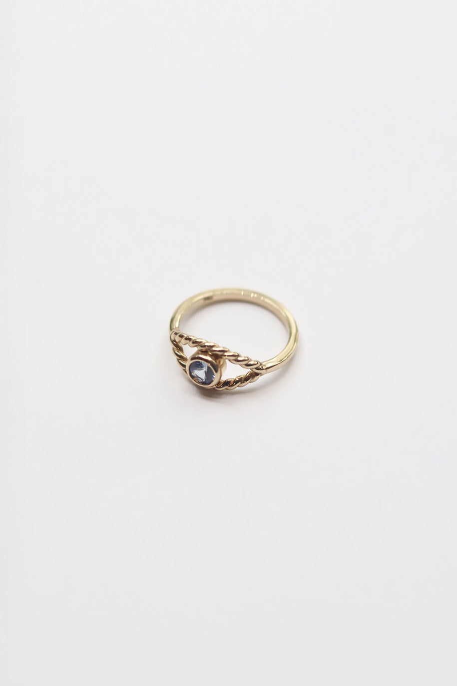 Gold ring with a purple gemstone on a white background